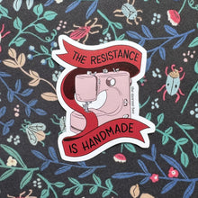 Load image into Gallery viewer, Sticker with sewing machine graphic and 'The Resistance is Handmade' text on a floral patterned background.
