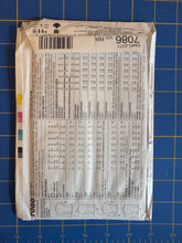Load image into Gallery viewer, A flat lay of a Sew-It! brand sewing pattern envelope, pattern number 1086, showing the back with size charts and garment illustrations, placed on a blue cutting mat.
