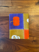 Load image into Gallery viewer, Small fabric square with a pumpkin design on a wooden surface
