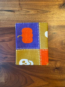 Small fabric square with a pumpkin design on a wooden surface